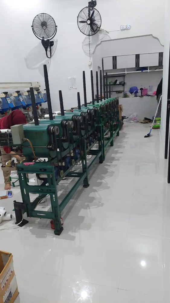Barisan panjang mesin twisting benang di lantai produksi