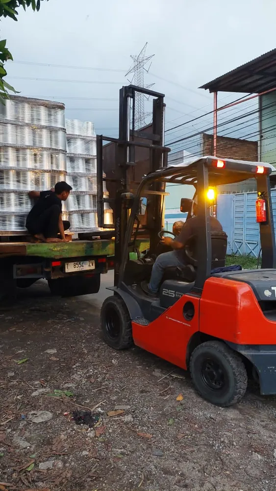 Forklift memuat palet benang ke atas truk pengiriman