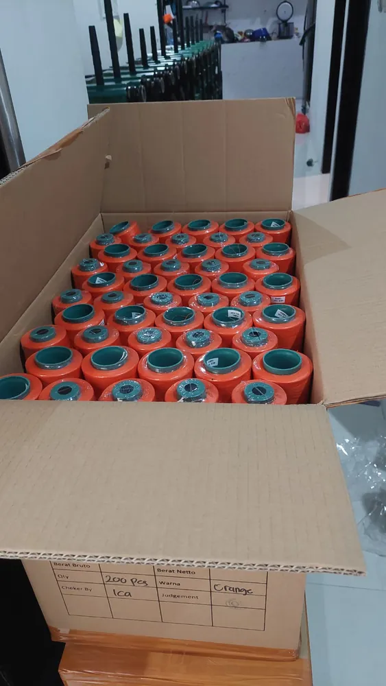 Dus benang warna oranye berisi 200 pcs dengan label pemeriksaan QC