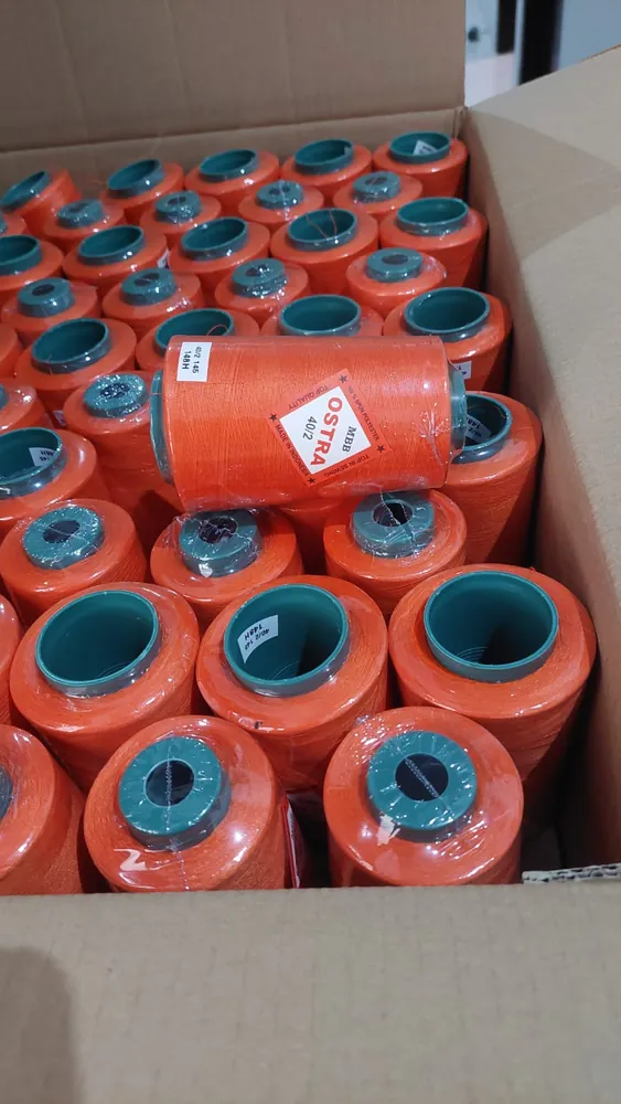 Cone benang OSTRA MBB 40/2 warna oranye tertata dalam dus