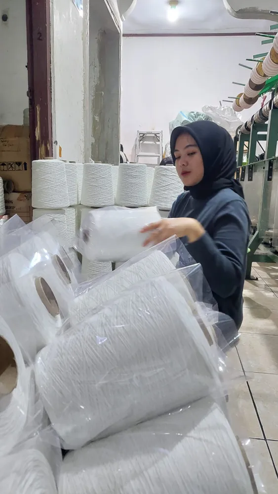 Proses pengemasan cone benang ke dalam plastik pelindung
