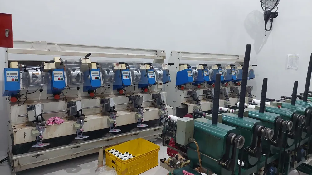 Ruang produksi dengan mesin penggulung berpanel digital dan mesin twisting