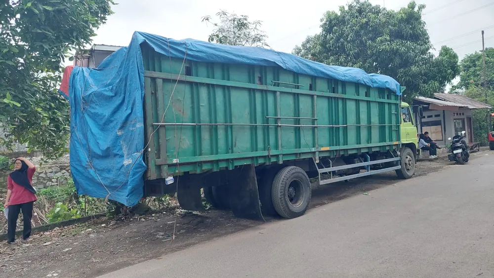 Truk bermuatan benang tertutup terpaulin siap berangkat